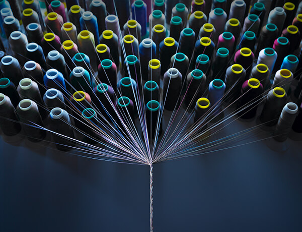 Many different spools of threat being spun into one strand