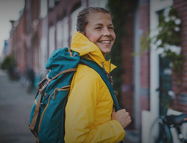 Female wearing a green backpack and yellow rain jacket