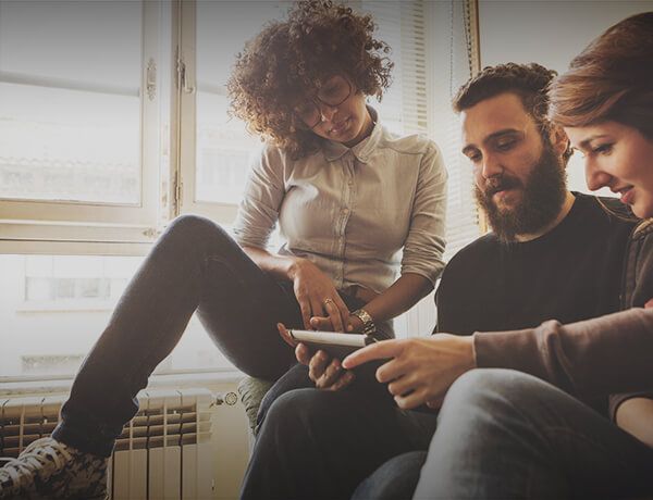 3 people looking at a tablet