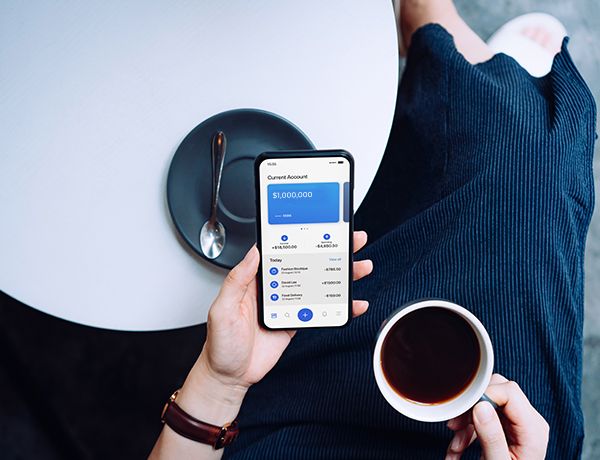 Overhead look at person on their phone drinking coffee
