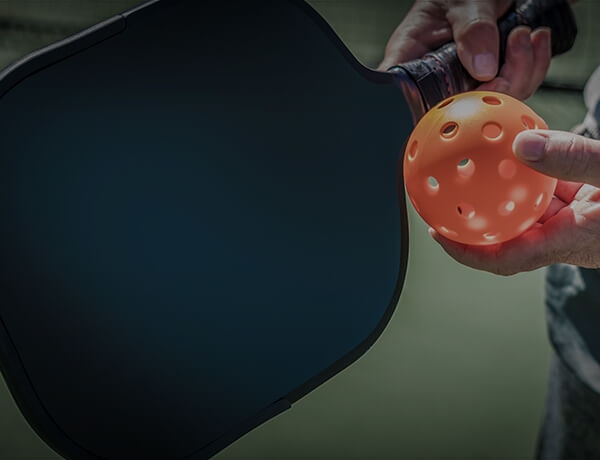 Closeup of pickleball paddle and ball