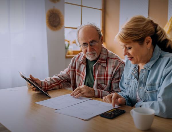 Man and woman look at paper on table